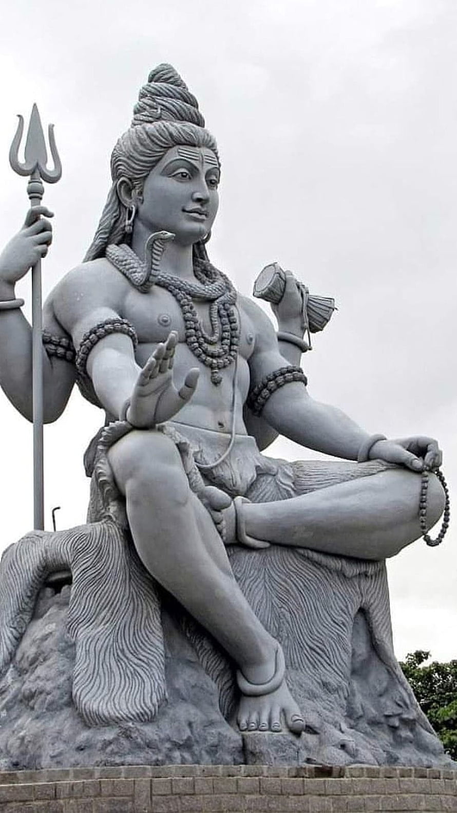 Majestic Lord Shiva Statue Holding Trishul and Damaru in Serene Meditation Pose HD phone wallpaper
