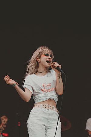 Hayley Williams performing live on stage in a white Pure Pleasure t-shirt HD phone wallpaper