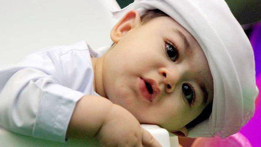 Adorable Muslim Baby Boy Wearing Traditional White Cap and Outfit HD wallpaper