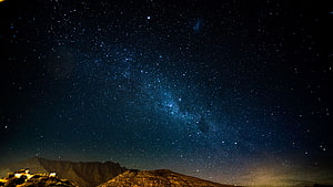 Milky Way Galaxy Arching Over Dark Mountain Ranges Under a Star-Filled Night Sky HD wallpaper