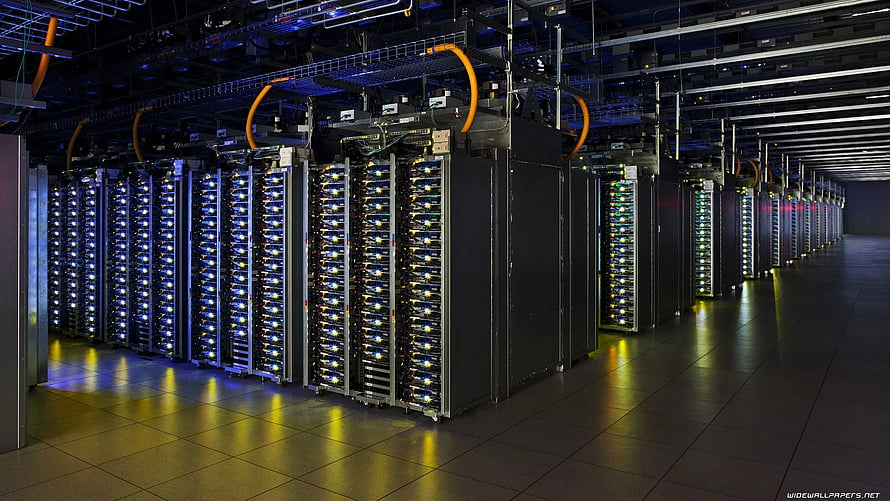 Rows of illuminated server racks in a modern data center with blue and yellow lighting HD wallpaper