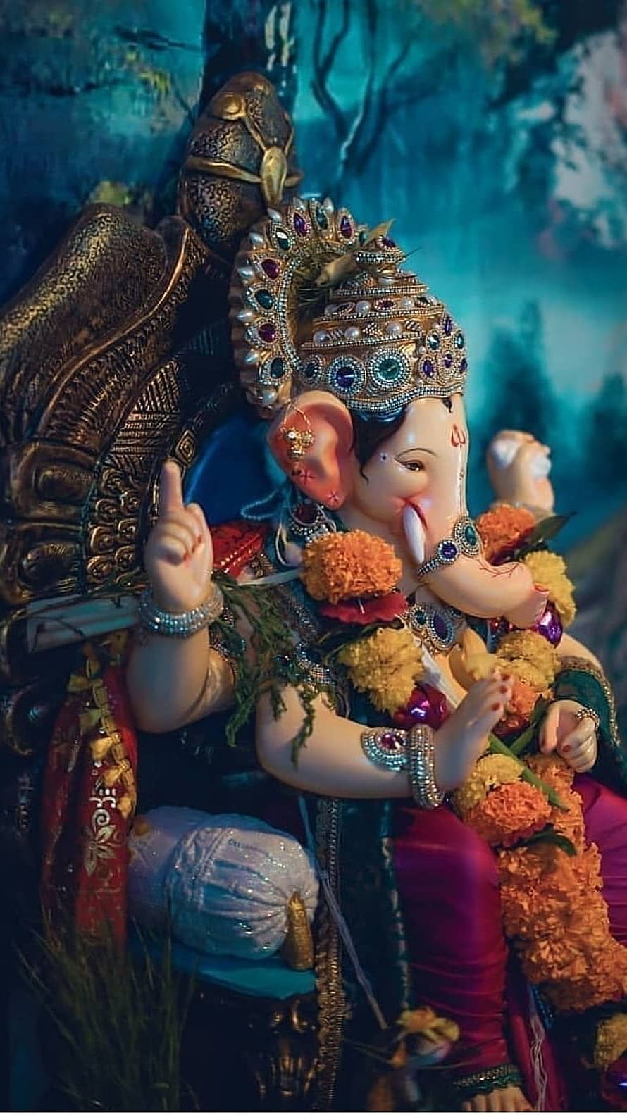 Ornate Ganesha Statue with Floral Garlands and Jeweled Crown HD phone wallpaper
