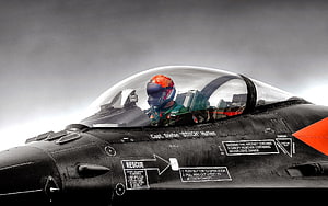 Combat Pilot in Fighter Jet Cockpit with Orange Helmet and Black Aircraft Fuselage HD wallpaper