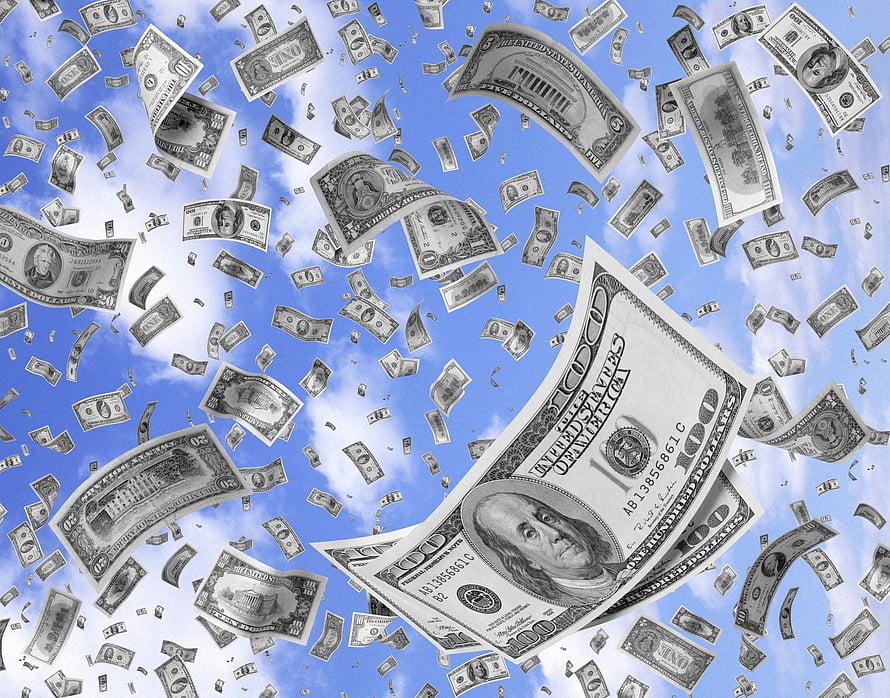 US Dollar Bills Falling Against a Bright Blue Sky with White Clouds HD wallpaper