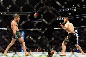Khabib Nurmagomedov and Conor McGregor face off in the UFC octagon during a championship bout HD wallpaper