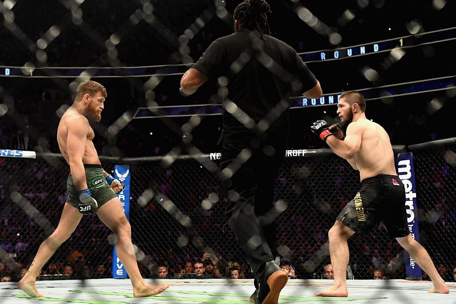 Khabib Nurmagomedov and Conor McGregor face off in the UFC octagon during a championship bout HD wallpaper