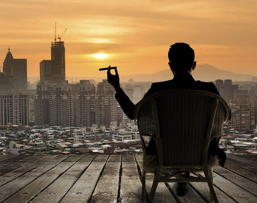 Silhouette of a man in a suit holding a cigar overlooking a city skyline at sunset, Billionaire Lifestyle , Billionaire Man HD wallpaper