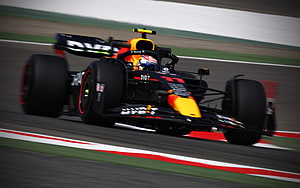 Sergio Perez in the Red Bull Racing RB18 Formula 1 car speeding on a race track HD wallpaper