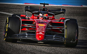 Ferrari Formula 1 race car speeding on the track with driver in cockpit HD wallpaper