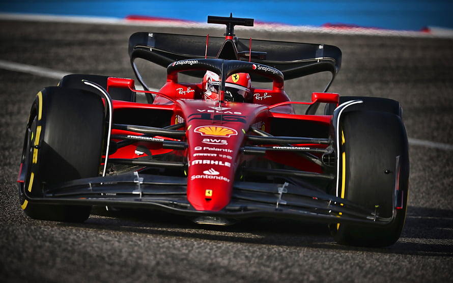 Ferrari Formula 1 race car speeding on the track with driver in cockpit HD wallpaper