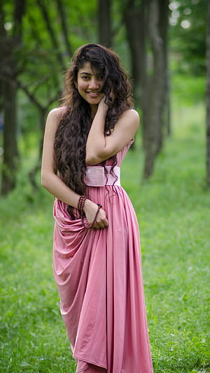 Beautiful Woman in Pink Dress Standing in Green Forest with Long Curly Hair, South Heroine, Sai Pallavi HD phone wallpaper