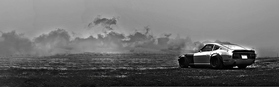 Classic Muscle Car Parked on a Grassy Field Under Dramatic Storm Clouds HD wallpaper