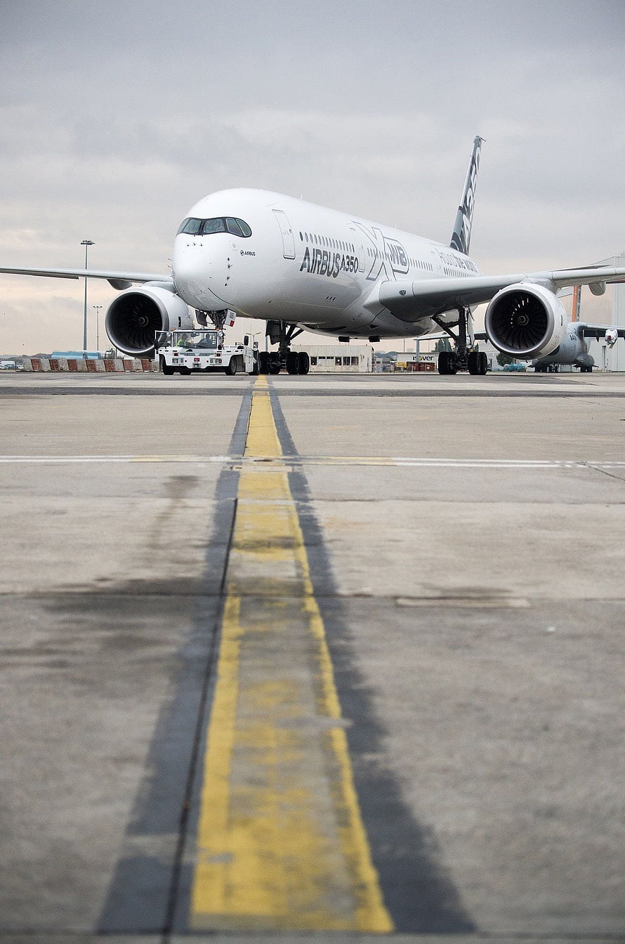 Airbus A350 XWB wide-body jet on airport taxiway with tow vehicle and overcast sky HD phone wallpaper