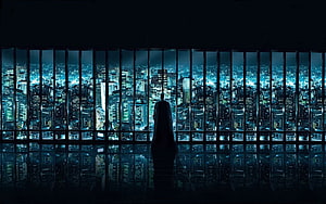 Silhouetted Figure in Cape Overlooking a Glowing Cityscape at Night HD wallpaper