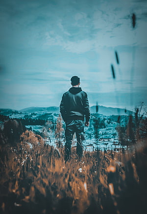 Man Standing in Tall Grass Overlooking Mountain Valley Landscape, Sad boy mood off, cloud, sky HD phone wallpaper
