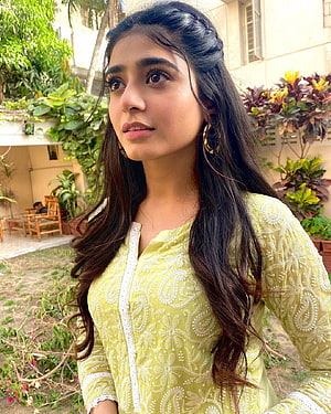 Sehar Khan in a yellow embroidered kurta with long wavy hair in a garden setting HD phone wallpaper