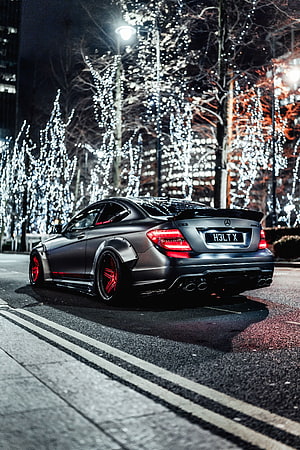 Matte Black Mercedes-Benz C63 AMG Coupe with Red Accents Parked on City Street at Night HD phone wallpaper