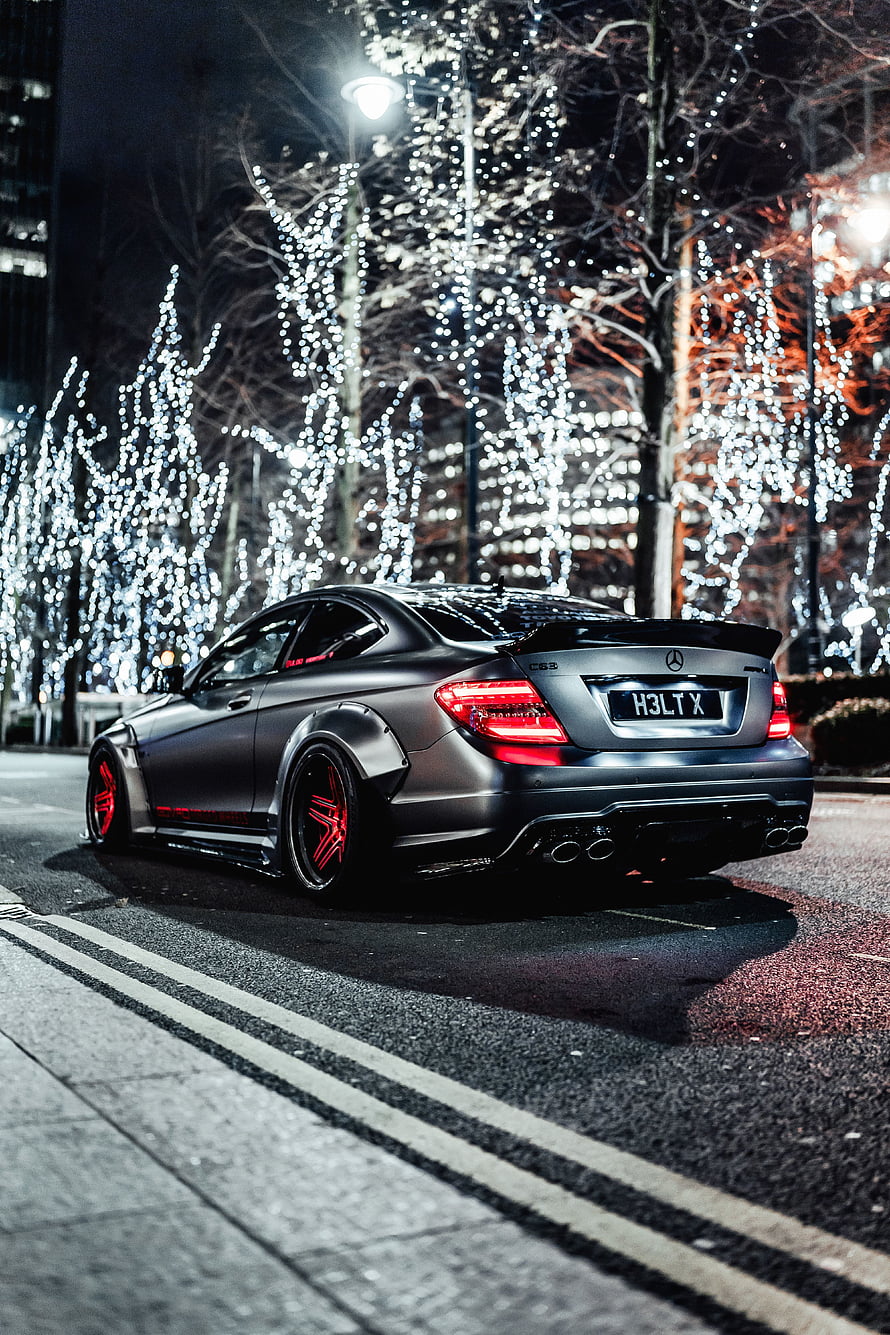 Matte Black Mercedes-Benz C63 AMG Coupe with Red Accents Parked on City Street at Night HD phone wallpaper