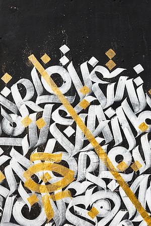 Abstract Street Art Mural With White Calligraphy And Gold Geometric Accents On Black Wall HD phone wallpaper