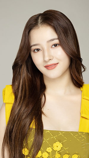 Nancy from Momoland in a yellow floral dress with long brown hair smiling portrait HD phone wallpaper