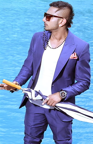 Yo Yo Honey Singh in a purple suit with sunglasses and a folded umbrella against a blue backdrop HD phone wallpaper