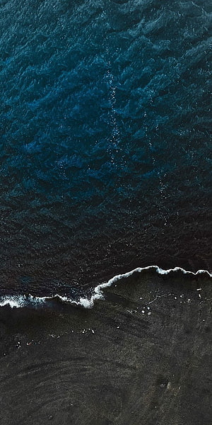 Aerial View of Dark Ocean Waves Meeting a Black Sand Beach HD phone wallpaper