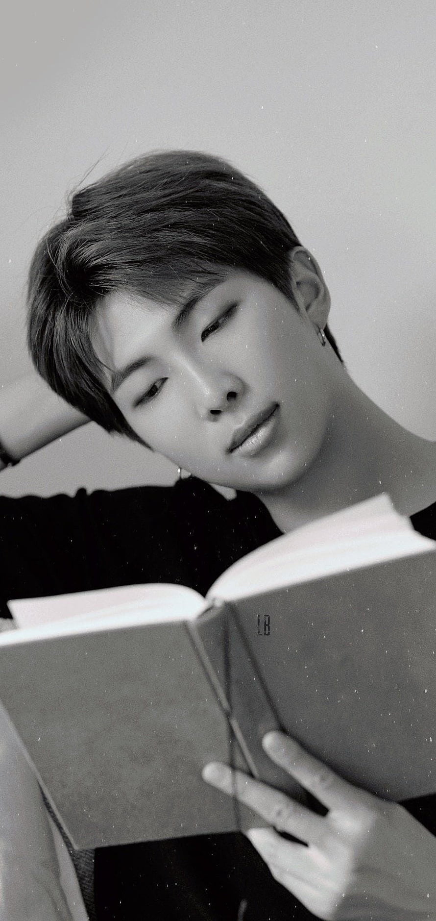 RM from BTS in a moody black and white portrait reading a book HD phone wallpaper