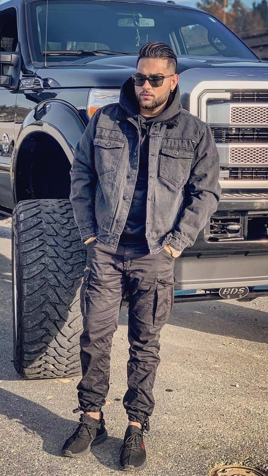 Man in Black Denim Jacket and Cargo Pants Standing in Front of a Lifted Ford F-250 Truck, Karan Aujla, Punjabi Singer HD phone wallpaper