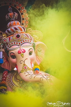 Ganesha Idol With Yellow Holi Colors And Ornate Jewelry HD phone wallpaper