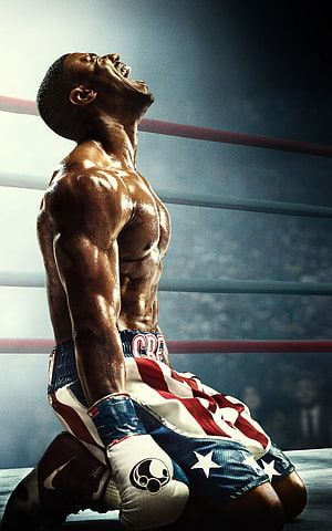 Adonis Creed kneeling in the ring with American flag trunks and boxing gloves HD phone wallpaper