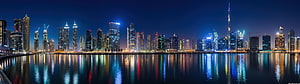 Dubai Marina skyline at night with Burj Khalifa and colorful reflections on the water HD wallpaper