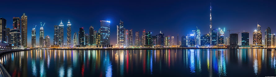 Dubai Marina skyline at night with Burj Khalifa and colorful reflections on the water HD wallpaper