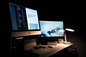 Minimalist Dual Monitor Developer Desk Setup with Apple iMac and Code Editor in Dark Room HD wallpaper
