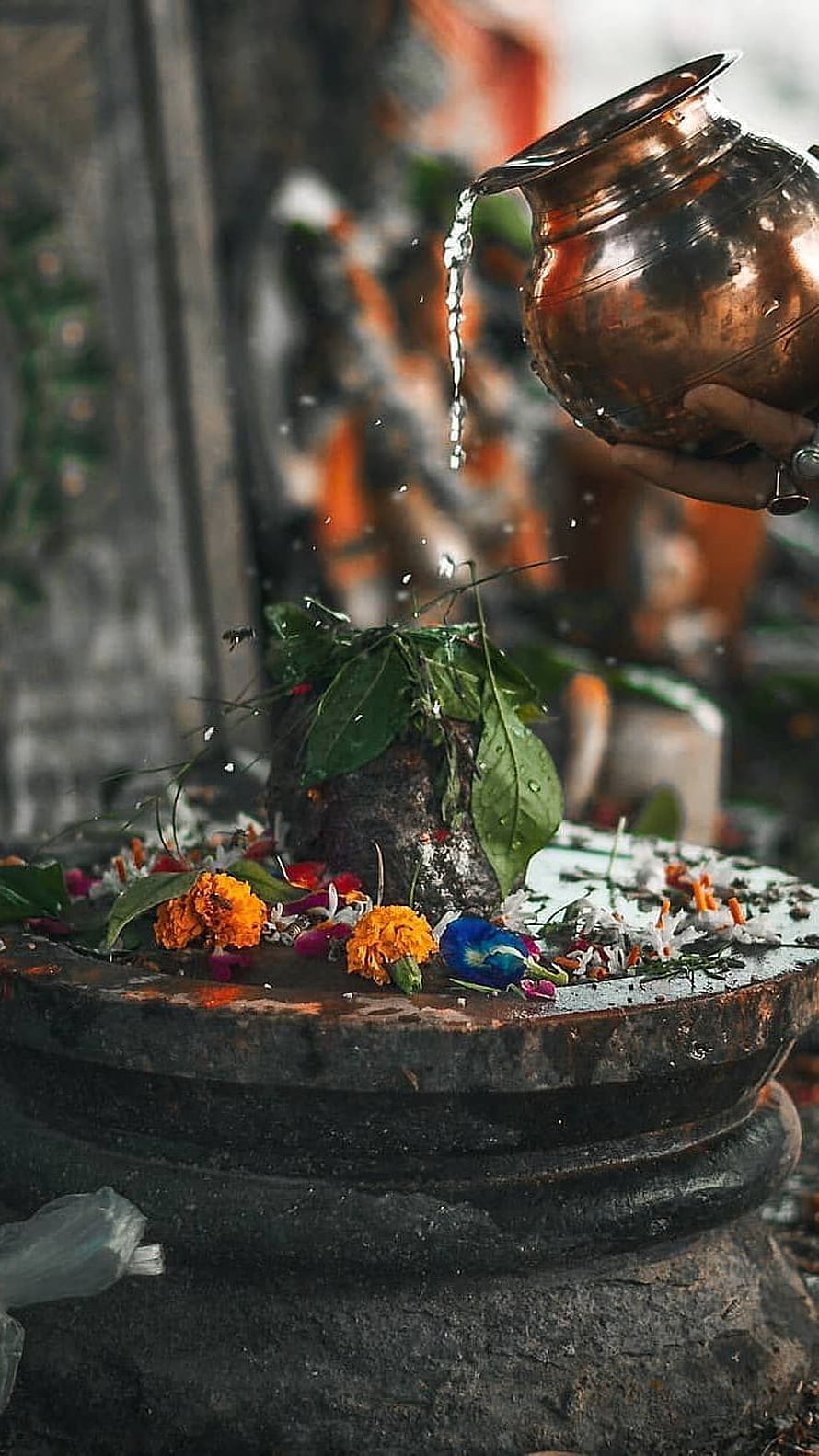 Hindu Ritual Pouring Water on Shiva Lingam with Copper Pot and Marigold Flowers HD phone wallpaper