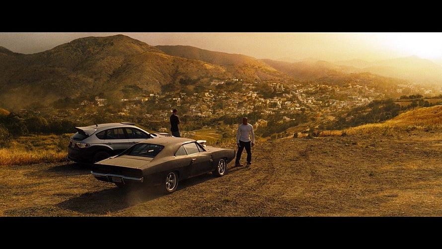 Fast and Furious 4 cinematic scene with classic muscle car on a golden hour hillside overlooking a coastal town HD wallpaper