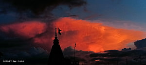 Silhouetted Temple Spire Against Dramatic Fiery Sunset Clouds HD wallpaper