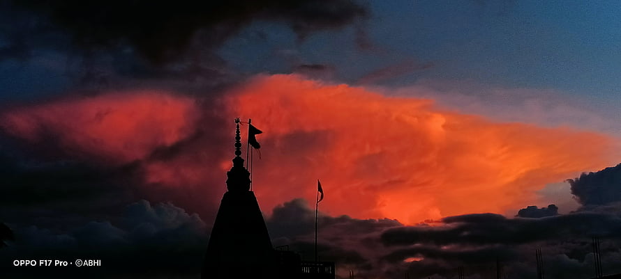 Silhouetted Temple Spire Against Dramatic Fiery Sunset Clouds HD wallpaper