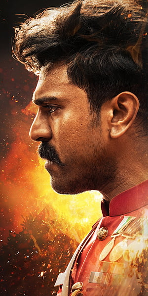 Ram Charan in RRR military profile portrait with fiery explosion background and medals HD phone wallpaper
