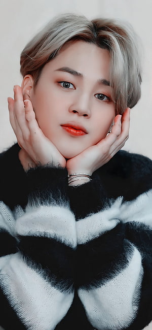 Pantipa, a Thai actress, is featured in a close-up portrait with her hands gently cupping her face. She has short, light-colored hair and is wearing a black and white striped sweater. HD phone wallpaper