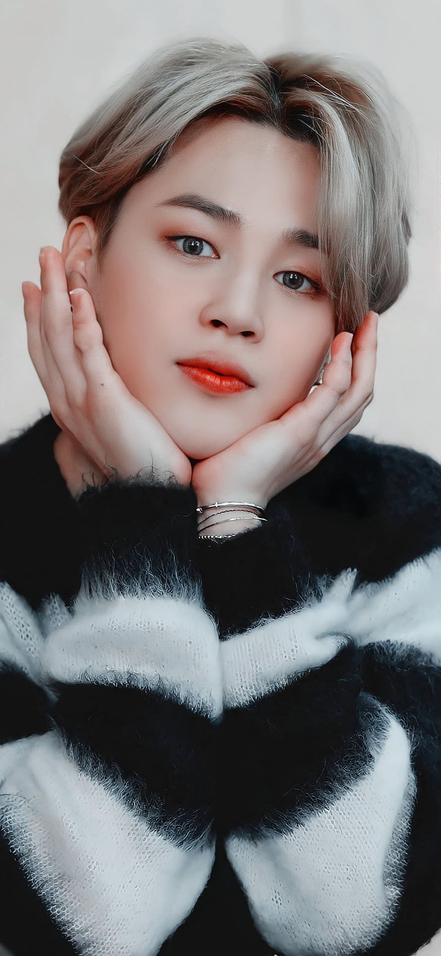 Pantipa, a Thai actress, is featured in a close-up portrait with her hands gently cupping her face. She has short, light-colored hair and is wearing a black and white striped sweater. HD phone wallpaper