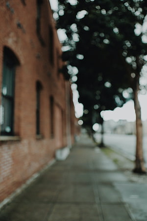 Blurred Urban Street Scene With Red Brick Building And Trees HD phone wallpaper