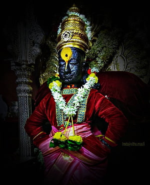 Statue of Lord Shiva adorned with a golden crown and flower garlands in a temple HD phone wallpaper