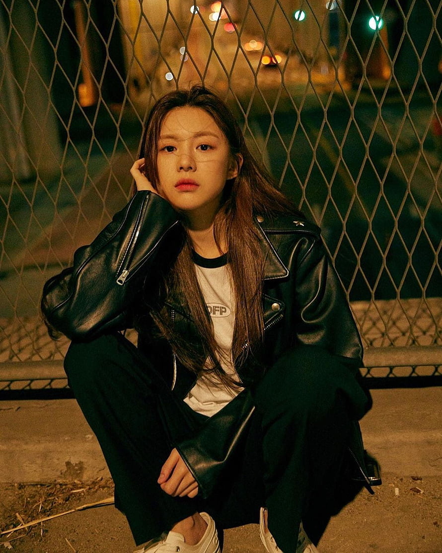Young woman in black leather jacket crouching by chain-link fence at night, Go Yoon Jung HD phone wallpaper