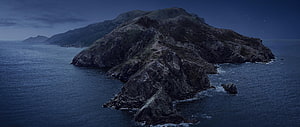 Moody Aerial View of Rugged Coastal Island at Dusk with Dark Ocean Waters HD wallpaper