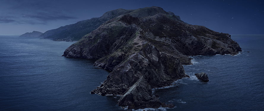 Moody Aerial View of Rugged Coastal Island at Dusk with Dark Ocean Waters HD wallpaper