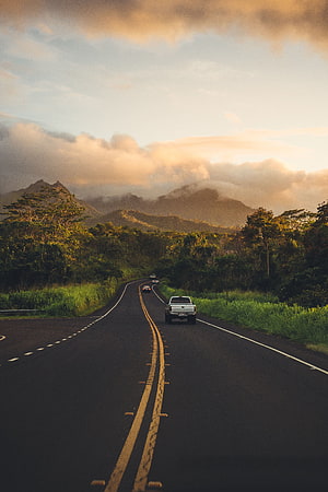 Winding Highway Through Lush Tropical Valley With Distant Mountain Peaks At Golden Hour HD phone wallpaper