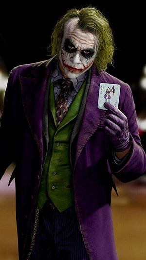 Heath Ledger as The Joker in a purple suit holding a playing card HD phone wallpaper