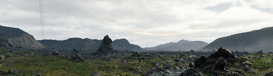 Death Stranding Vast Rocky Landscape with Faint Rainbow Arc and Distant Mountain Peaks HD wallpaper