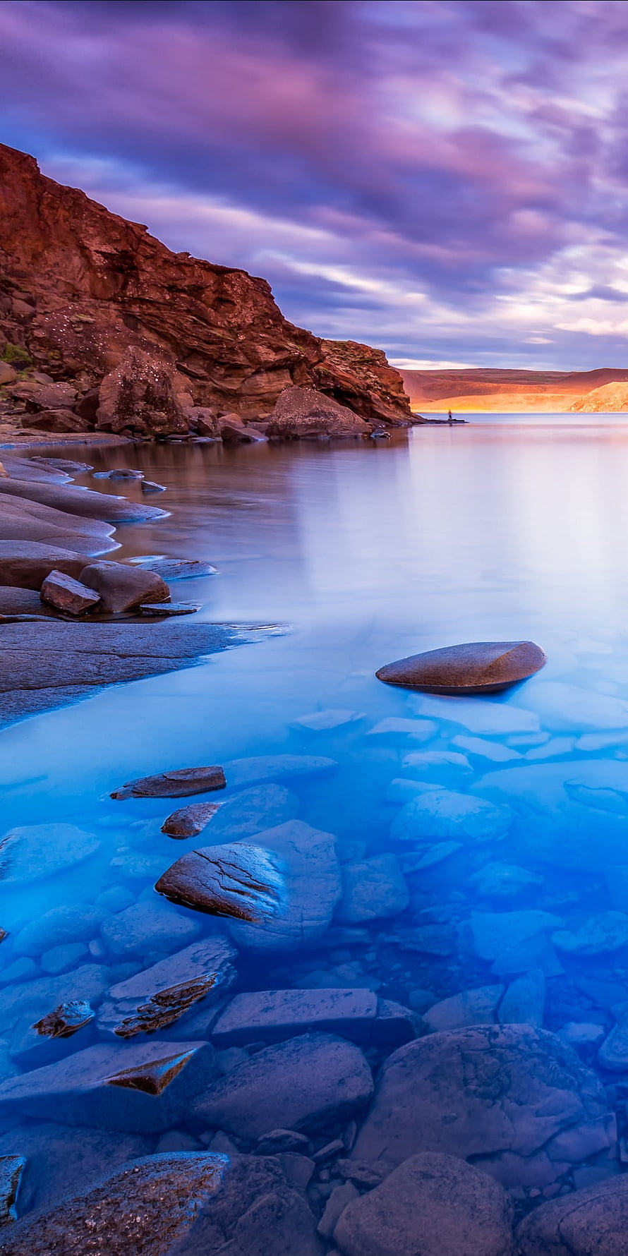 Serene Blue Lagoon with Smooth Rocks and Purple Sunset Sky HD phone wallpaper