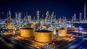 Illuminated Petrochemical Plant at Night with Storage Tanks and Distillation Columns HD wallpaper